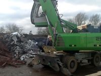 Excavator collecting scrap metal